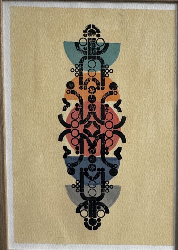 Figure symétrique de motifs noirs, roses et bleus sur papier beige