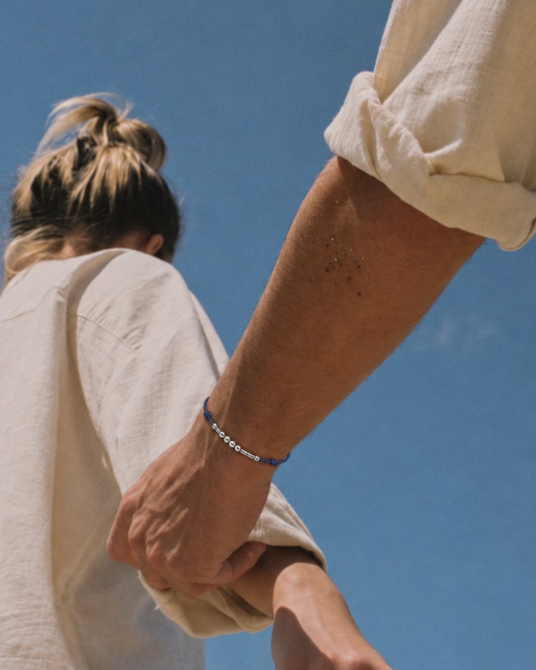 Le bracelet porté, bras levé sur un ciel bleu